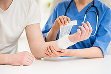 Image of physician bandaging patient's arm